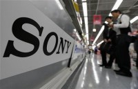 A Sony logo is seen as customers look at Sony's digital cameras at an electronic shop in Tokyo